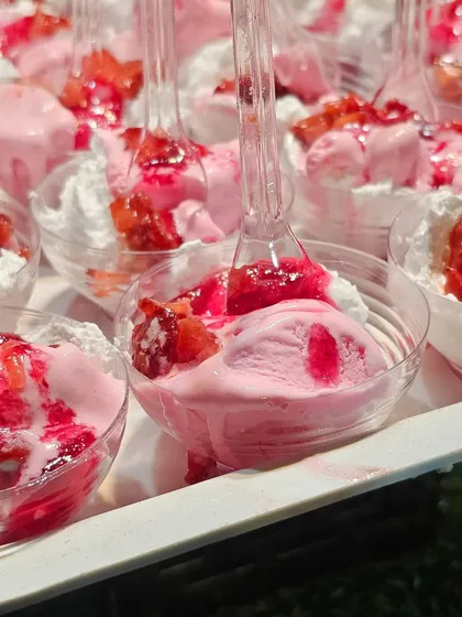 Strawberry ice cream cups with fresh cream and syrup, a simple and beloved dessert for all ages.