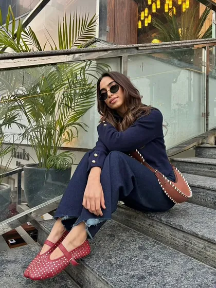 A confident pose in our red studded ballet flats. The combination of the classic denim with the bold red shoe creates a timeless look with a modern twist.