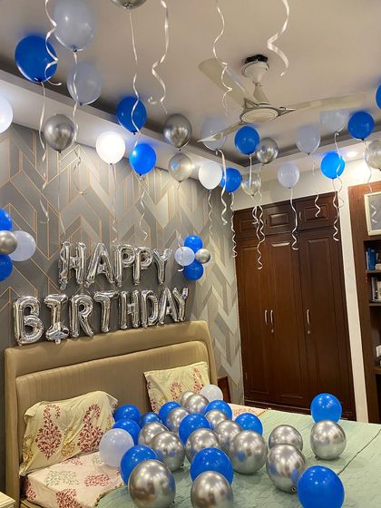 This wide shot shows how the coordinated blue and silver balloons completely transform the room for a festive birthday celebration.