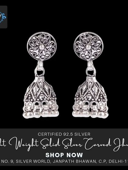 A classic pair of solid silver carved jhumkis. The intricate filigree work on the stud and the detailed pattern on the bell showcase traditional Indian jewelry techniques.