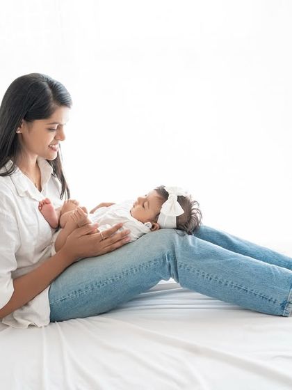 A mother and baby relaxing on a bed in the studio.