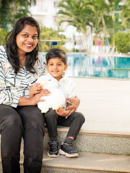 A mother and son enjoying a quiet moment together by the pool. The peaceful setting is perfect for a relaxed and loving portrait.