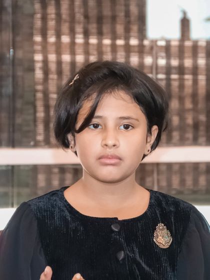 A candid portrait of a young girl at a party, showing the natural and unposed moments of the day.