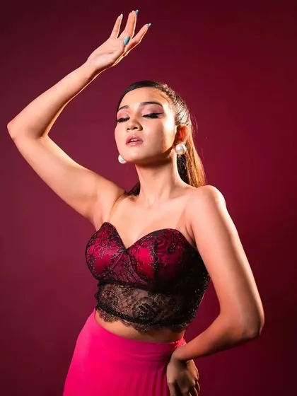 An expressive, artistic pose that showcases the clean lines of the makeup and the polished finish of the high ponytail.
