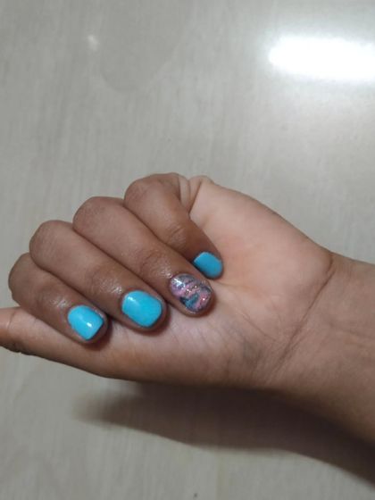 A simple yet artistic design on short, natural nails. I used a bright sky blue gel polish as the base and added a delicate floral marble effect on the ring finger. It’s a great way to add a touch of art to a simple manicure.