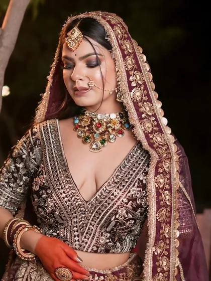 A series of portraits of a bride in a deep wine-colored lehenga. The outdoor, nighttime setting shows the outfit's versatility for reception or sangeet shoots.