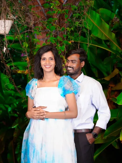 A beautiful candid shot of the couple surrounded by lush greenery. The natural lighting and genuine smiles make this a truly special photo.