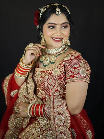 A classic portrait of the bride, adjusting her earring. The red rose in her hair adds a touch of romance to the overall look.