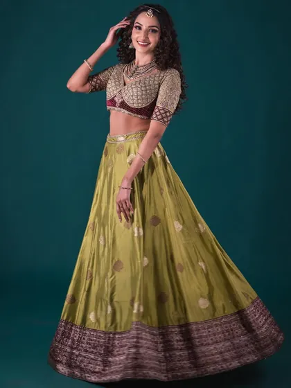 A dynamic shot of the model in the olive green Banarasi lehenga, showing the beautiful movement of the skirt and the intricate details of the blouse.