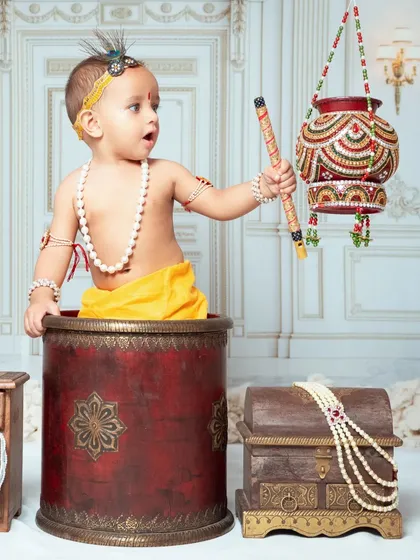 A playful little Krishna pops out of a pot during our Janmashtami mini session. We use fun props to get the most expressive photos.