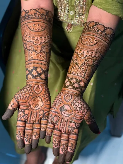 A close-up of a heavy bridal design, showing the fine lines and details. This piece features peacocks and floral motifs, perfect for a bride who wants a rich and traditional look.