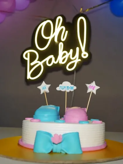 The baby shower cake with its "Oh Baby!" topper and balloon background. We compose our shots to include the surrounding decorations.