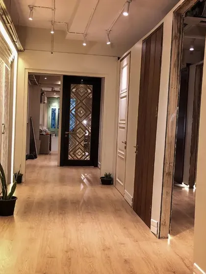 This view of the showroom highlights some of my most intricate door designs, including a white carved door and another with a geometric metal inlay.