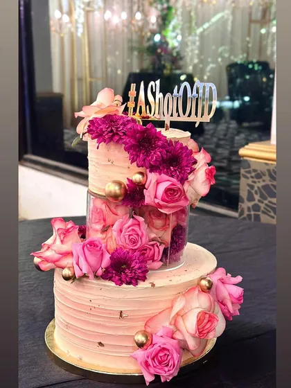 Celebrating a union of togetherness with this gorgeous three-tier engagement cake. Made with our bestselling decadent chocolate cake and vanilla buttercream, it’s adorned with fresh pink and magenta florals and touches of gold for a soft, romantic feel. We love creating the centerpiece for your big day.