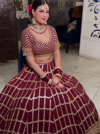 The complete look of the maroon peplum lehenga with a scalloped skirt design. This is a great choice for an engagement or reception.