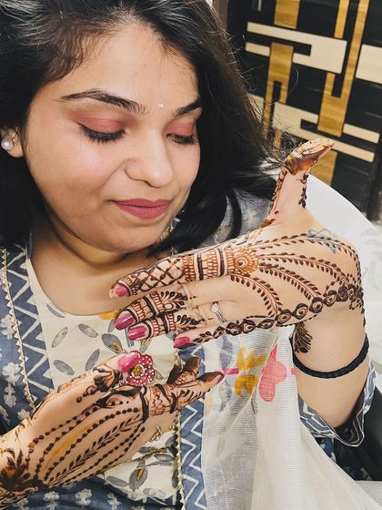 A happy client showing off her simple and elegant mehndi design, perfect for any party or small occasion.