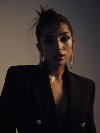 A powerful and direct portrait with dramatic lighting. The model's strong gaze and the edgy hairstyle combine to create a captivating and modern high-fashion look.