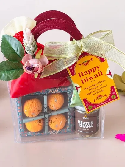 A budget-friendly corporate gift option. This clear bag contains laddoo candles and a jar of beaten chana, finished with a festive tag.