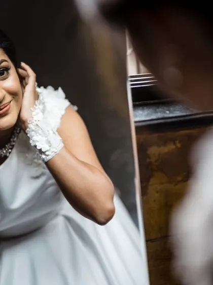 A candid shot of the bride admiring her reflection in the mirror. These getting-ready moments are perfect for capturing the anticipation and excitement of the wedding day.