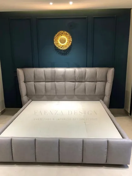 A modern bed with a winged, grid-tufted headboard in a cool grey fabric. The clean lines and contemporary design make it a perfect fit for a stylish, minimalist bedroom.