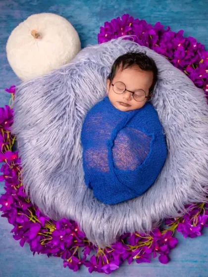 Dreaming in shades of blue and purple. The tiny glasses add a touch of scholarly charm to this otherwise peaceful and colorful newborn portrait.