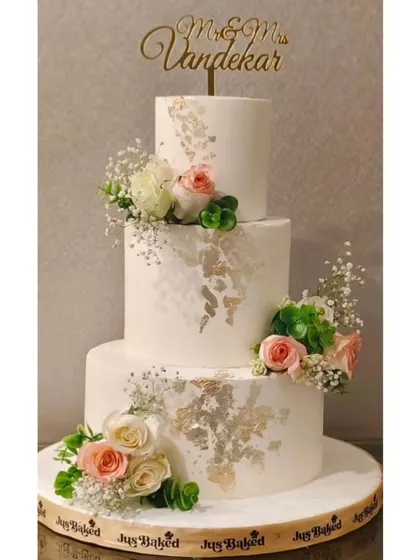 For a truly grand celebration, I created this three-tier eggless chocolate roasted hazelnut wedding cake. It combines rich flavor with the elegance of fresh flowers and delicate 24K gold leaf accents, making it a memorable centerpiece.
