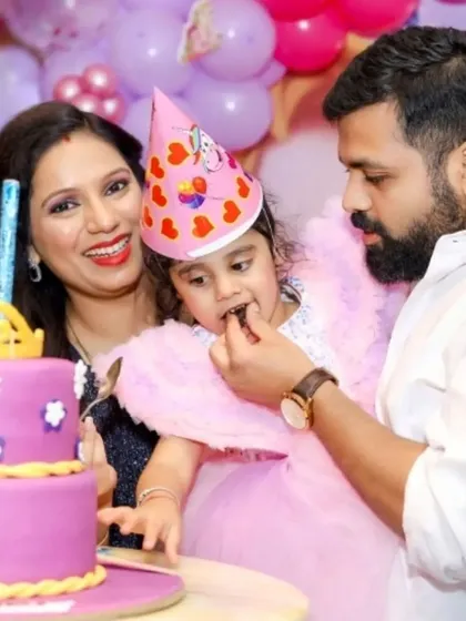 A father helps his daughter with her first taste of birthday cake. We love getting close-up shots of these sweet, unposed moments that define a family celebration.