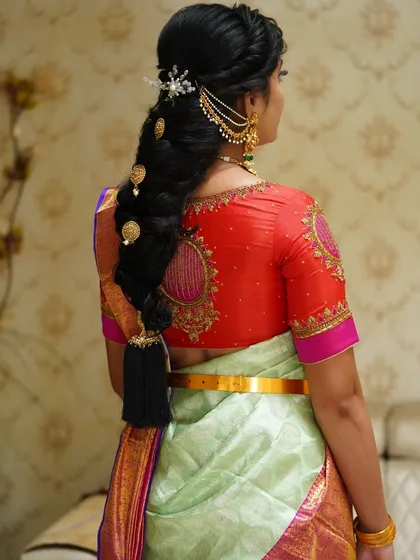 A beautiful hairstyle is just as important as the makeup. Here, we created a stunning traditional braid, adorned with classic hair accessories, to perfectly complement her Kanchipuram silk saree.