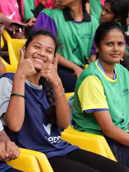 A young fan gives a thumbs-up at the ICC Criiio Cricket Festival. We managed this multi-city grassroots event to promote women's cricket, handling everything from venue management to transportation.