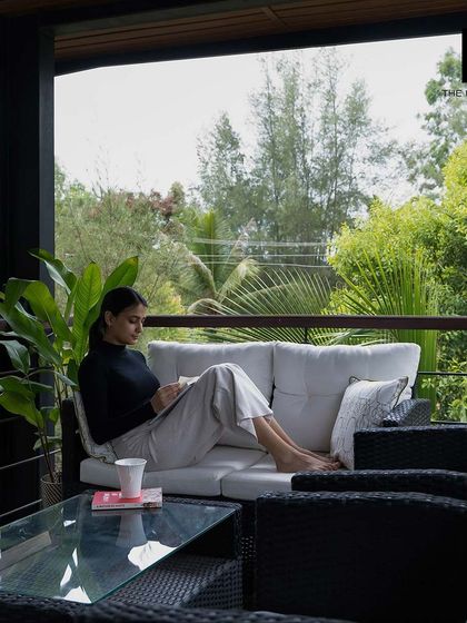 A moment of relaxation on the balcony of our 2BHK cargo home, surrounded by lush greenery.
