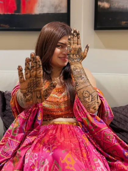 A playful pose from the bride, highlighting the design on one palm and the back of the other hand. This shows the versatility and beauty of the complete bridal package.