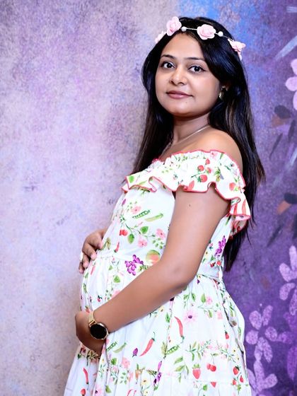 A classic and elegant portrait of the mother-to-be. Her direct gaze and gentle hold on her belly create a confident and beautiful maternity photograph.
