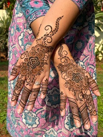 A lovely floral design centered on the back of the hands. The swirling vines and detailed finger work make this a popular choice for festive occasions.