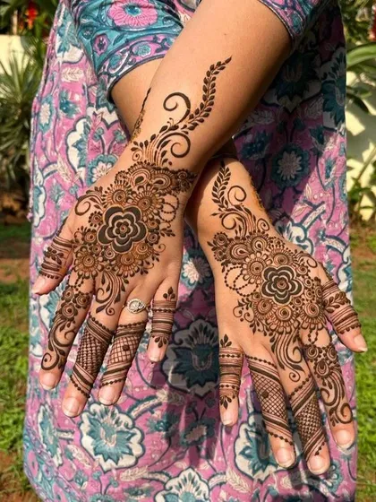 A lovely floral design centered on the back of the hands. The swirling vines and detailed finger work make this a popular choice for festive occasions.