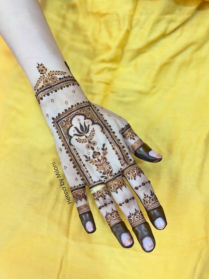 A single hand view of the minimal lotus arch design, showing its delicate and graceful placement on the back of the hand.