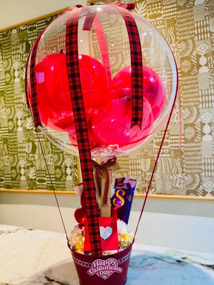 The full view of the Bobo balloon hamper, a whimsical and sweet Valentine's gift with a Giva pendant, chocolates, and a teddy bear inside.