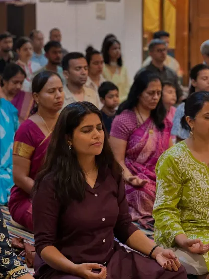 A group of women deep in meditation. The focused, serene expressions show the calming effect of the practice.