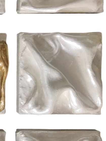 A detail of one of the all-silver dancers. Their surfaces swirl in graceful, unified steps, blending into a seamless choreography of light and shadow.