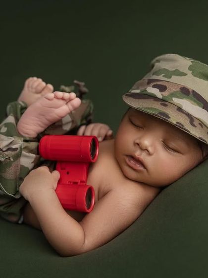 A close up of the little trooper, capturing the soft details of his face as he sleeps. The contrast between the rugged camo and his delicate features is what makes this shot so special.