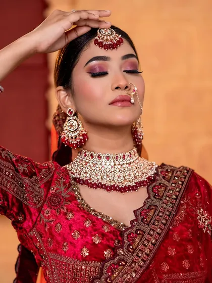 A close-up of the North Indian bride, focusing on the dramatic eye makeup and maang tikka.