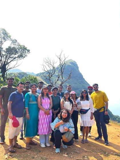 Another group posing near the iconic tree at a Chikmagalur viewpoint.