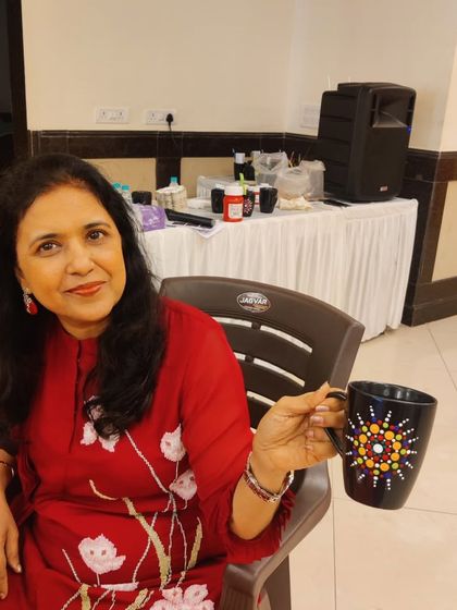 Another member of the ladies' group with her finished dot mandala mug, a perfect result from a relaxing and social art session.