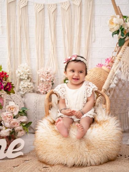 Perched on a fluffy stool, this little one is the star of her boho-themed shoot. The mix of textures, from the macrame to the fur, adds depth and interest.