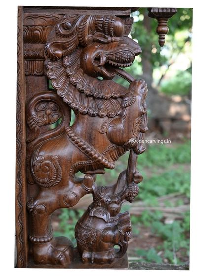 A close-up of the Yaali's head and the elephant it holds in its trunk, showcasing the fierce expression and detailed carving.