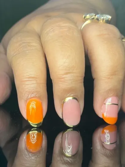 A bright and playful design with orange and pink nails featuring gold foil outlines and stripes.