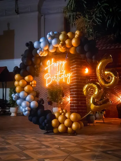 This outdoor birthday decoration shows how I can create a stylish party atmosphere in any setting. The modern balloon arrangement in black, gold, and silver, combined with a neon sign against a brick wall, gives a cool, urban vibe to the celebration.