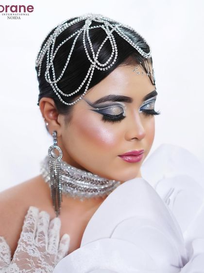 A close-up on the shimmering silver eyeshadow and the crystal headpiece, demonstrating skill in detailed accessory work.