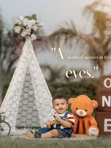 A world of wonder in their eyes. This outdoor first birthday shoot combines a teepee, "ONE" blocks, a teddy bear, and a ukulele for a picture-perfect setup.
