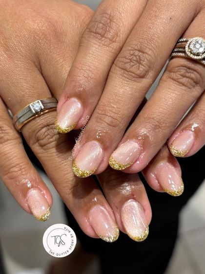 A similar take with gold glitter tips. This look is warm and festive, proving that a simple switch to a gold glitter French can completely change the vibe.