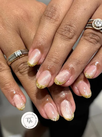 A sparkling gold glitter French tip manicure. This is a perfect look for festive occasions or for anyone who loves a bit of glamour.